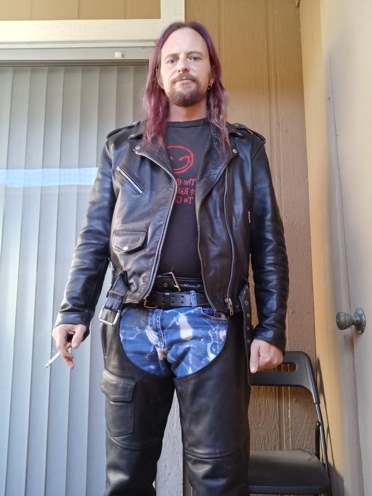 Standing in full leathers with a cigarette in my hand.