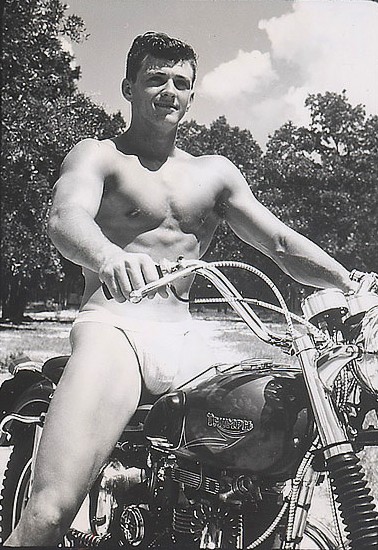 Darryl Powers riding a Triumph motorcycle in his jockstrap