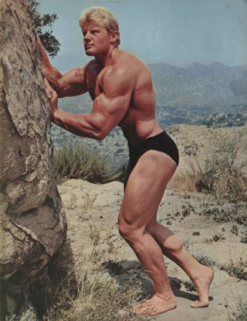 Dave Draper poses against a rock in the desert near Los Angeles.