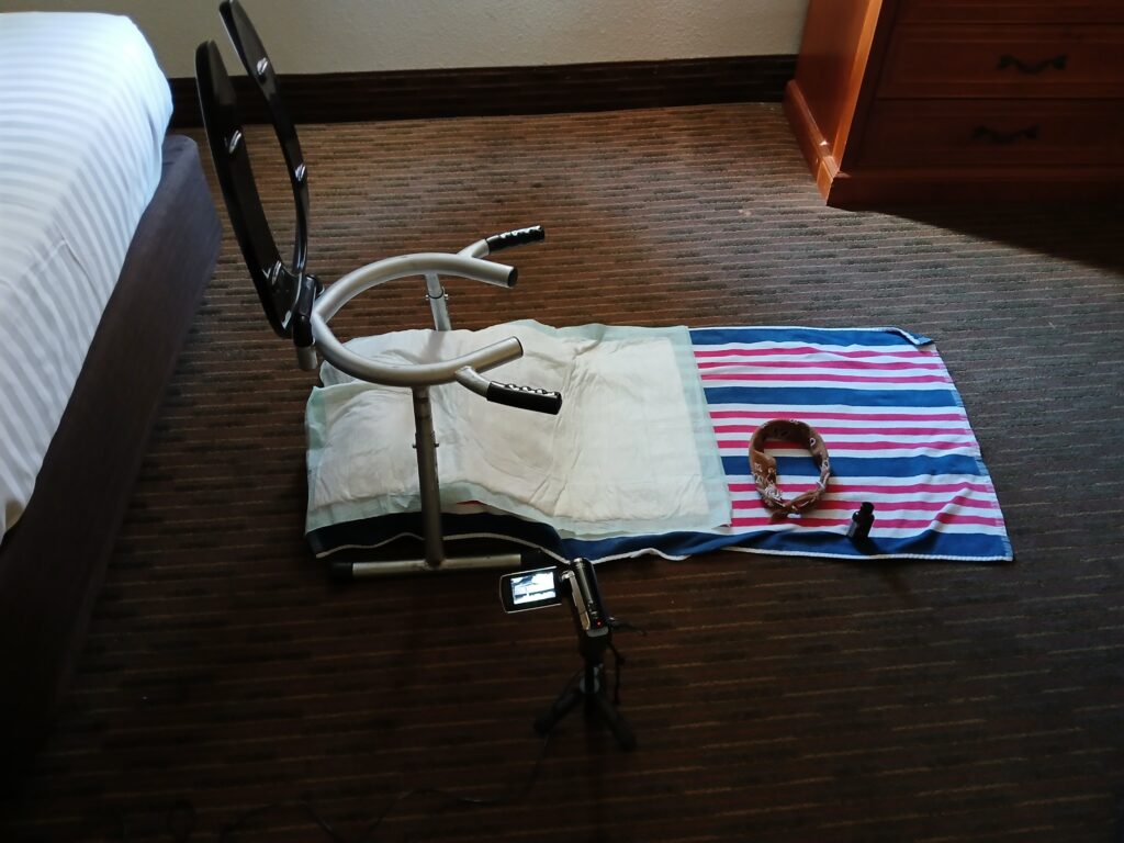 Rimseat, puppy pad, blindfold, and poppers prepared before a camera set to capture the scat action on video.