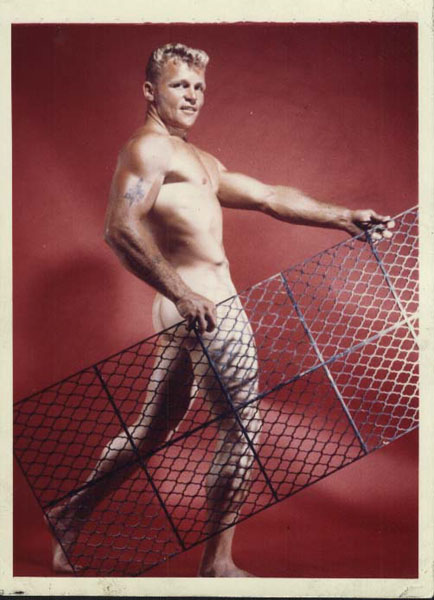 Lance Arlen poses against a red backdrop with an ornamental grate.